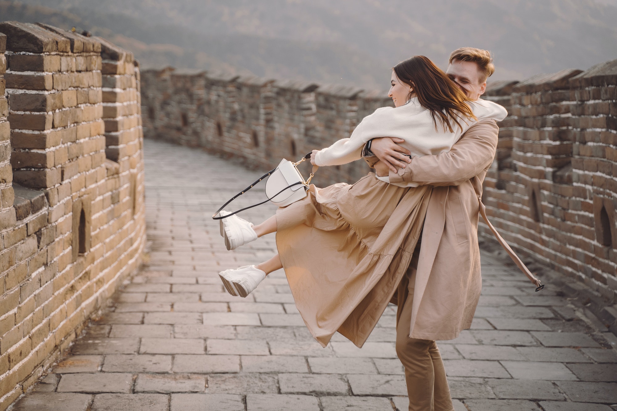 young couple running and twirling at the Great Wall of China